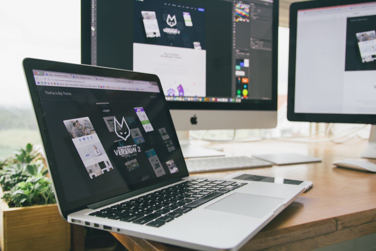 Laptop + desktop web-design workspace showing a WordPress theme