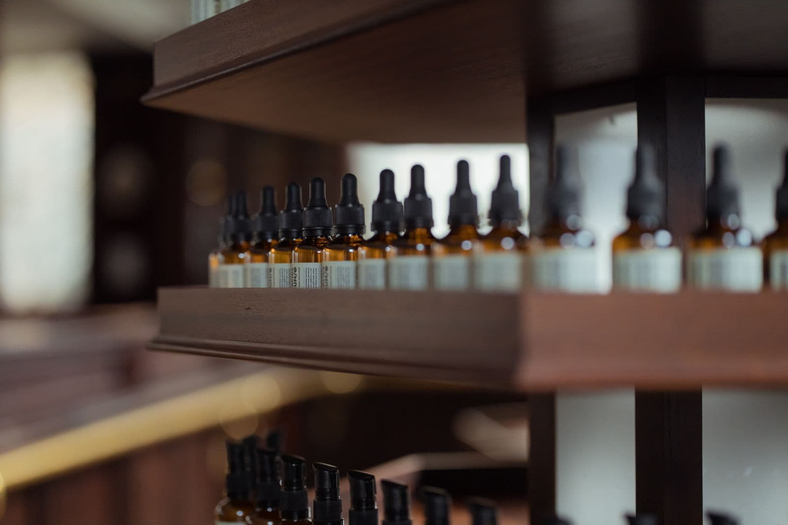 Amber dropper/supplement bottles on wooden shelves in a wellness store
