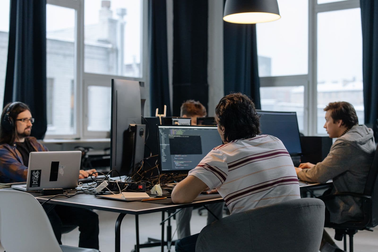 Team of developers coding at workstations in a modern tech office